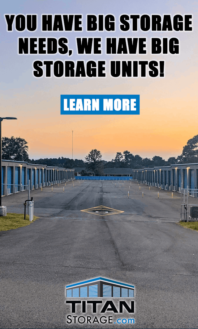 Entrance to Titan Storage in Spanish Fort with open gate at sunset showing the wide driveway and oversized doors to the large 15-foot by 50-foot storage units